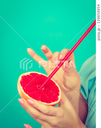Woman drinking juice from fruit, red grapefruit 139858954