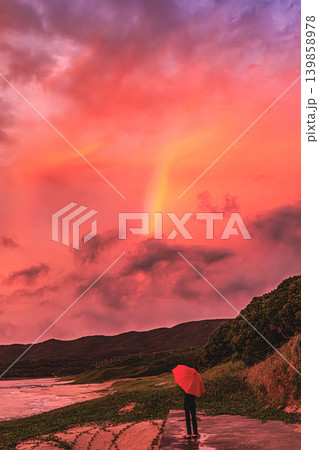 種子島の夕暮れ、赤い傘と虹が出会った花里浜公園の海辺 種子島の夕暮れ、赤い傘と虹が出会った花里浜公園の海辺 139858978