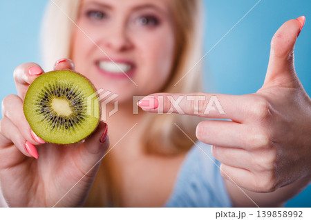 Woman holding green kiwi fruit Woman holding green kiwi fruit 139858992