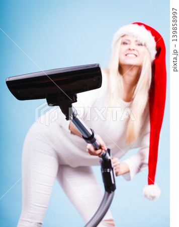 Girl in santa helper hat with vacuum cleaner Girl in santa helper hat with vacuum cleaner 139858997