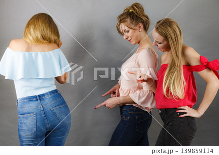 Women gossiping about friend body shape Women gossiping about friend body shape 139859114