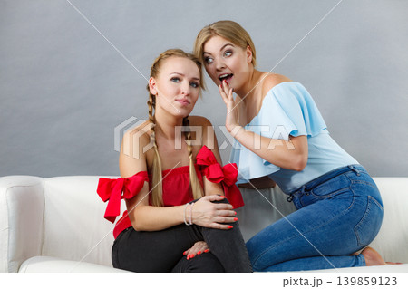 Two teen women gossiping Two teen women gossiping 139859123