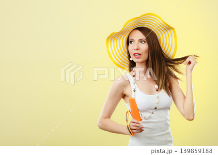 Woman in summer hat holds sunglasses sunscreen lotion 139859188