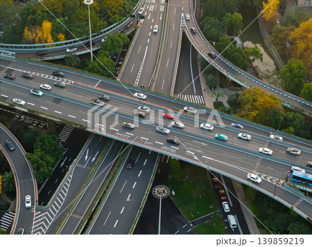 Aerial perspective captures a bustling multilevel highway interchange with cars moving across various elevated lanes in a vibrant Chinese city Aerial perspective captures a bustling multilevel highway interchange with cars moving across various elevated lanes in a vibrant Chinese city 139859219