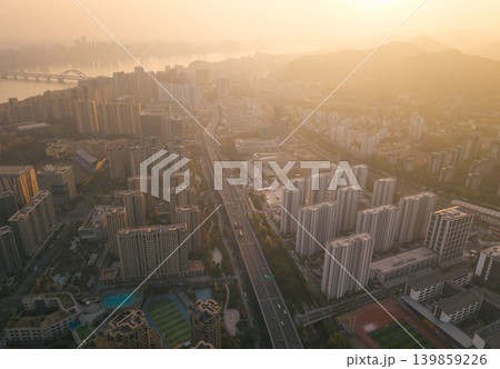 Expansive urban landscape at golden hour, showcasing countless residential skyscrapers, a flowing river, and active highway Expansive urban landscape at golden hour, showcasing countless residential skyscrapers, a flowing river, and active highway 139859226