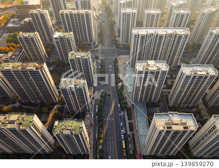 High-rise residential buildings dominate a dense urban landscape, arranged around wide roads and a central intersection High-rise residential buildings dominate a dense urban landscape, arranged around wide roads and a central intersection 139859270