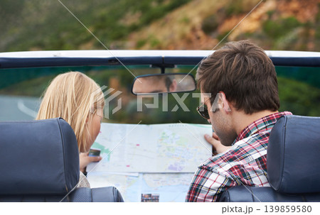 Map, driving and back of couple in a car for travel to vacation, adventure or holiday destination. Reading, atlas guide and young man and woman on journey in vehicle for weekend road trip together. Map, driving and back of couple in a car for travel to vacation, adventure or holiday destination. Reading, atlas guide and young man and woman on journey in vehicle for weekend road trip together. 139859580