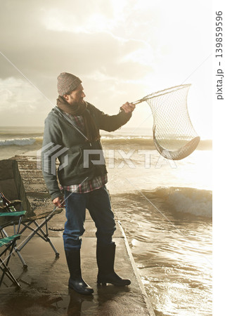 Sunshine, net and beach with man, fish and hobby with equipment, waves and weekend break. Person, ocean and guy with tools for activity and happiness with shore, pier and seaside with lens flare Sunshine, net and beach with man, fish and hobby with equipment, waves and weekend break. Person, ocean and guy with tools for activity and happiness with shore, pier and seaside with lens flare 139859596