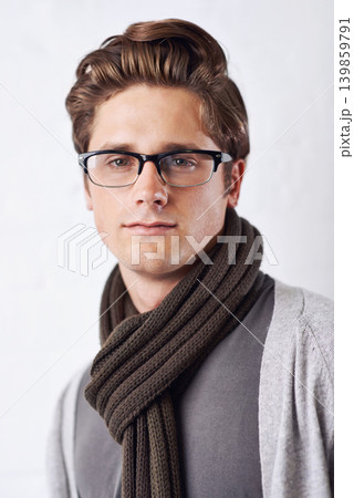 Glasses, style and portrait of man by wall with casual, cool and trendy outfit for confidence. Serious, handsome and young male person with spectacles and fashion standing by white brick background. Glasses, style and portrait of man by wall with casual, cool and trendy outfit for confidence. Serious, handsome and young male person with spectacles and fashion standing by white brick background. 139859791
