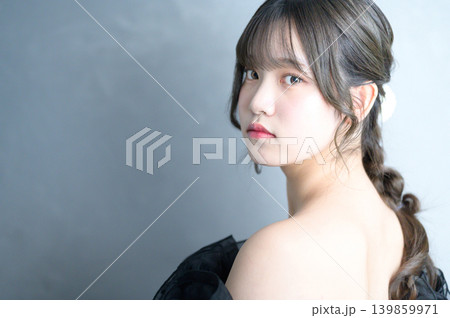 グレー背景で振り返る黒いドレスを着た日本人女性 グレー背景で振り返る黒いドレスを着た日本人女性 139859971