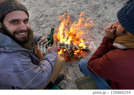 Campfire, friends and portrait with man and smile by the beach with vacation and camping. Ocean, outdoor and together with travel and people on a trip and journey with fire conversation by sea 139860254