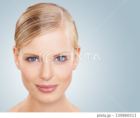 Portrait, skincare and woman with cosmetics, wellness and beauty on a blue studio background. Face, person or model with shine and makeup with grooming or dermatology with aesthetic, mockup or facial 139860311