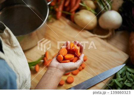 Vegetables, hands and person with carrot and wooden board for cooking lunch and nutrition diet at home. Wellness, health and organic food with meal, vegetarian and ingredients for salad in a kitchen Vegetables, hands and person with carrot and wooden board for cooking lunch and nutrition diet at home. Wellness, health and organic food with meal, vegetarian and ingredients for salad in a kitchen 139860323