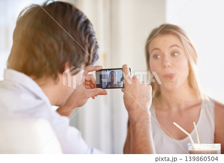 Couple, phone and photography for blog, memories and happiness with silly face at home on valentines day. Man, woman and photo in house, hotel and vacation for weekend getaway and romantic vlog Couple, phone and photography for blog, memories and happiness with silly face at home on valentines day. Man, woman and photo in house, hotel and vacation for weekend getaway and romantic vlog 139860504