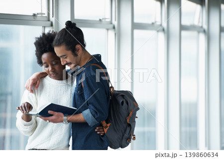 Couple, university and students with a book, hug and conversation for project and teamwork. College, man and woman with ideas or brainstorming with planning and education with embrace or knowledge 139860634
