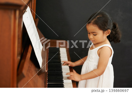Piano, girl and kid in home for learning, practice and classical education with musical notes. Training, melody and student with talent, creative or hobby with instrument, child development or skill Piano, girl and kid in home for learning, practice and classical education with musical notes. Training, melody and student with talent, creative or hobby with instrument, child development or skill 139860697
