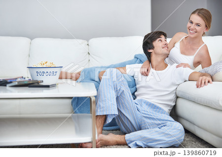 Couple, film and lying with living room, popcorn and sofa for relaxation and love or smile. People, home and romance for comfortable valentines day date and happiness for video or streaming movie Couple, film and lying with living room, popcorn and sofa for relaxation and love or smile. People, home and romance for comfortable valentines day date and happiness for video or streaming movie 139860719