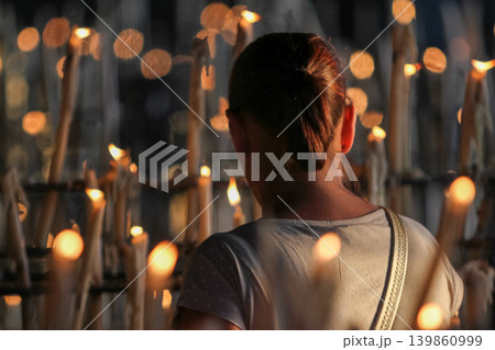 Catholic devotional ritual woman lighting candle in church Catholic devotional ritual woman lighting candle in church 139860999