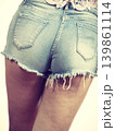 Slim girl wearing denim shorts back view 139861114