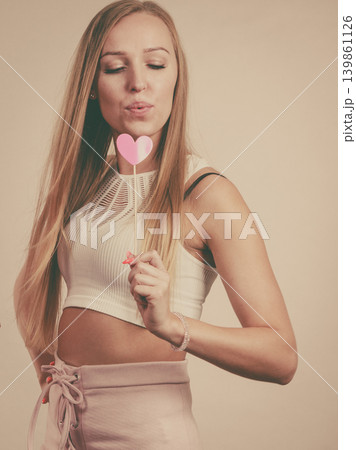 Happy woman holding heart on stick 139861126
