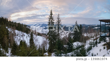 Evening winter snow-covered mountain ridge, Ukraine, Carpathians. Porch of an unrecognizable holiday cabin on the right. Evening winter snow-covered mountain ridge, Ukraine, Carpathians. Porch of an unrecognizable holiday cabin on the right. 139861974