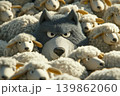 A felt wolf mingled with a flock of sheep. Odd one out. Wolf among sheep. 139862060