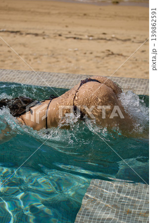 a girl with a beautiful tanned body having fun in the swimming pool of a luxury villa, the girl's butt is visible from under the water, azure water, splashes of water glow in the sun a girl with a beautiful tanned body having fun in the swimming pool of a luxury villa, the girl's butt is visible from under the water, azure water, splashes of water glow in the sun 139862591