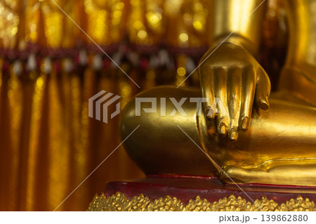 Closeup of golden Buddha hand resting knee ornate details symbolizing peace spirituality Buddhist devotion Closeup of golden Buddha hand resting knee ornate details symbolizing peace spirituality Buddhist devotion 139862880