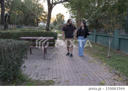 Couple Holding Hands Walking in Park. 139863564