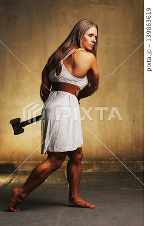 Young woman bodybuilder with hammer on wall background Young woman bodybuilder with hammer on wall background 139863619