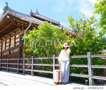 坂道の途中で一休みする旅行客の若い女性 坂道の途中で一休みする旅行客の若い女性 139864210