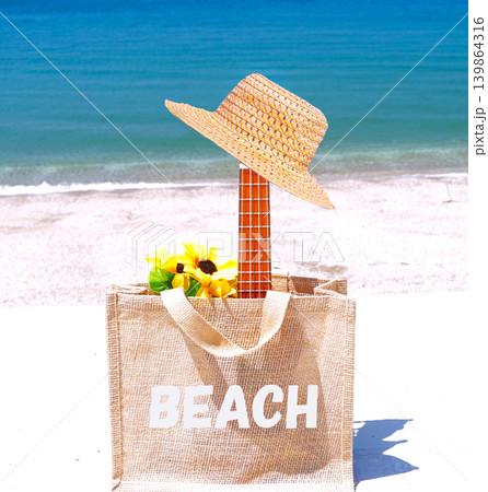 海辺に置かれたジュートバッグ&ウクレレ&ハット 海辺に置かれたジュートバッグ&ウクレレ&ハット 139864316
