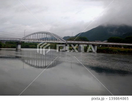 雨空の川面に映る白いアーチ橋の風景 139864865