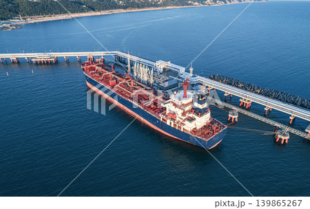Aerial view of a large oil tanker docked at a pier in the port in process of loading. 139865267