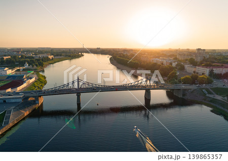 Golden sunset over Tver Russia shows the Old Volga Bridge carrying cars across the wide river 139865357