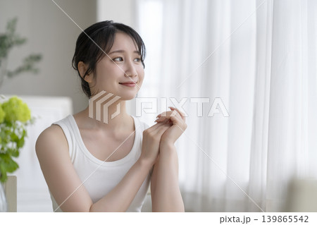 窓辺で微笑むアラサーの女性　ビューティーイメージポートレート 139865542