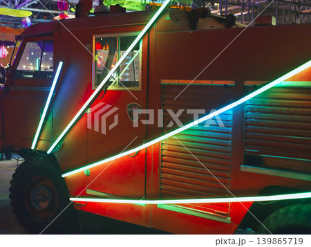 Neon lit armored vehicle at urban night gathering 139865719
