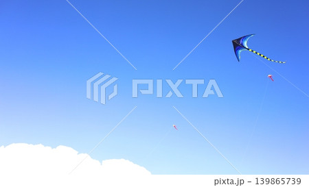 Kites Flying Across Clear Blue Sky 139865739