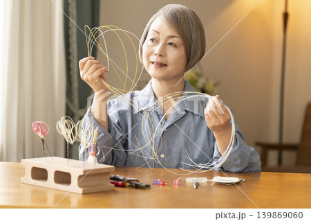 水引で髪飾りを作るシニア女性 水引で髪飾りを作るシニア女性 139869060