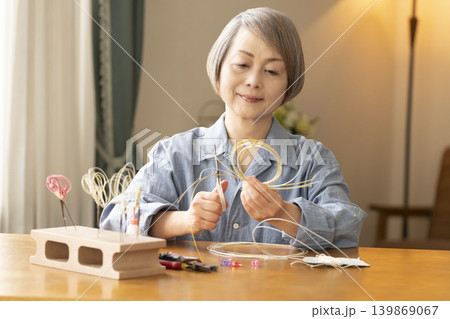 水引で髪飾りを作るシニア女性 水引で髪飾りを作るシニア女性 139869067
