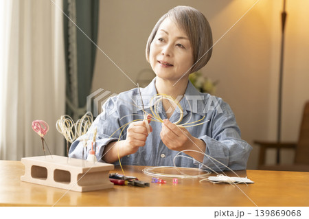 水引で髪飾りを作るシニア女性 水引で髪飾りを作るシニア女性 139869068