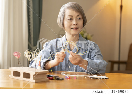 水引で髪飾りを作るシニア女性 水引で髪飾りを作るシニア女性 139869070