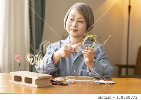 水引で髪飾りを作るシニア女性 水引で髪飾りを作るシニア女性 139869072