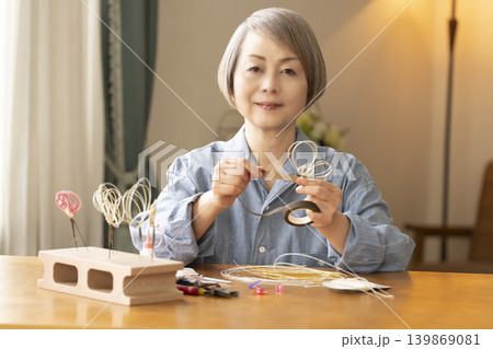 水引で髪飾りを作るシニア女性 水引で髪飾りを作るシニア女性 139869081