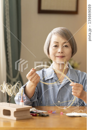 水引で髪飾りを作るシニア女性 水引で髪飾りを作るシニア女性 139869089