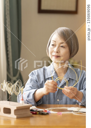 水引で髪飾りを作るシニア女性 139869096