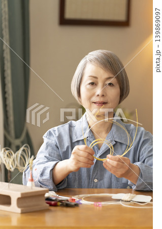 水引で髪飾りを作るシニア女性 水引で髪飾りを作るシニア女性 139869097