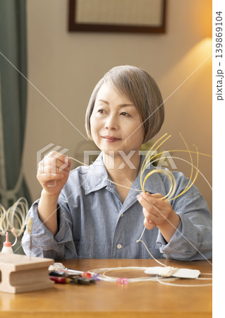 水引で髪飾りを作るシニア女性 水引で髪飾りを作るシニア女性 139869104