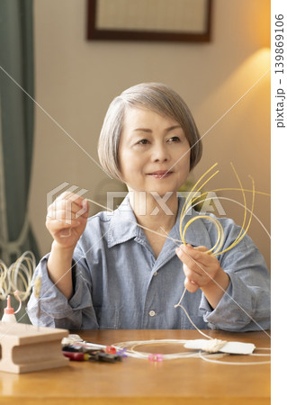 水引で髪飾りを作るシニア女性 水引で髪飾りを作るシニア女性 139869106