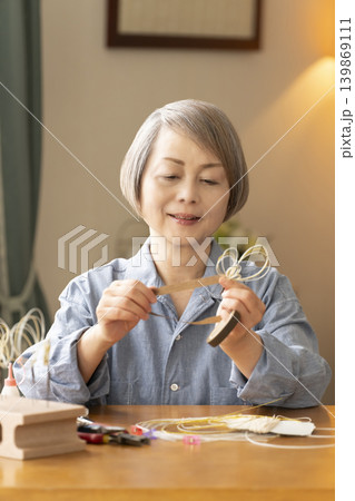 水引で髪飾りを作るシニア女性 水引で髪飾りを作るシニア女性 139869111